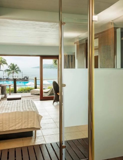 Luxurious suite with oceanfront view at a premier hotel in Seychelles, featuring a seamless blend of indoor comfort and natural outdoor beauty.