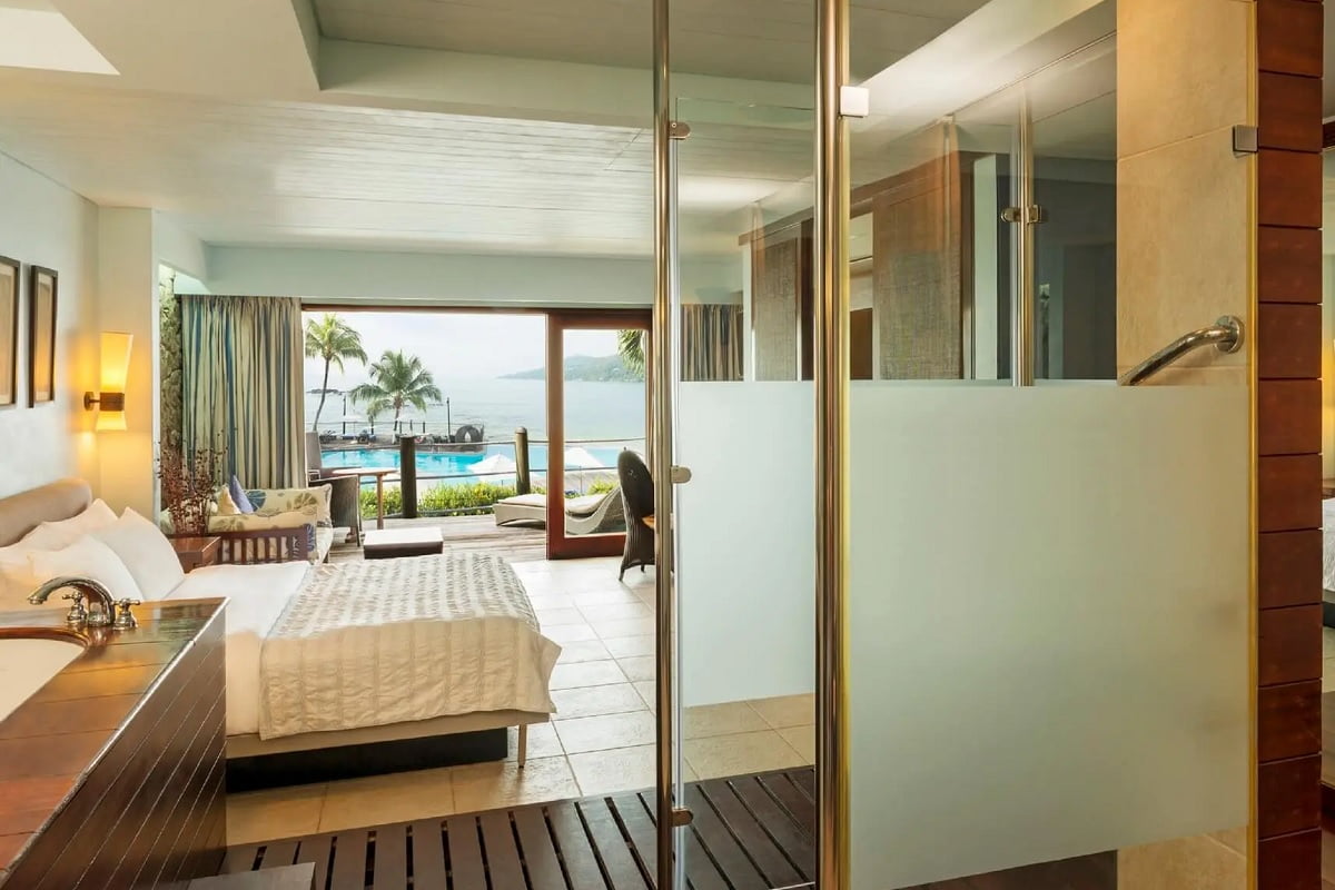 Luxurious suite with oceanfront view at a premier hotel in Seychelles, featuring a seamless blend of indoor comfort and natural outdoor beauty.