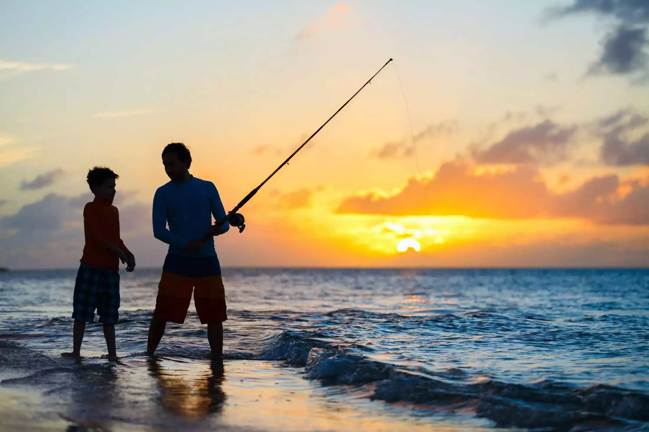 Family fly-fishing at sunset on a Seychelles Island.
